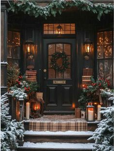 a black front door with christmas wreaths and lit candles on the steps next to it