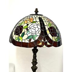 a stained glass table lamp on a white background with flowers in the center and leaves at the base