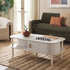 a living room with a couch, coffee table and chess set on the carpeted floor