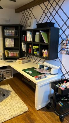 a room with a desk and shelves filled with crafting supplies