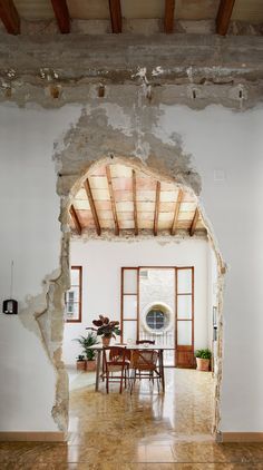 an open doorway leading to a dining room and living room with exposed brickwork on the walls