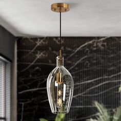 a glass light fixture hanging from a ceiling in a room with marble walls and flooring