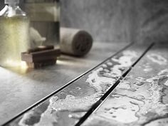 a close up of some metal tracks on a table with candles and toilet paper in the background