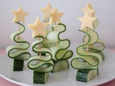 cucumber christmas trees on a white plate with candles in the shape of stars