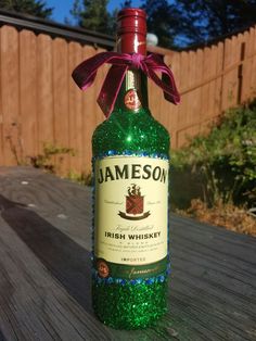 a bottle of jameson sitting on top of a wooden table with a pink bow around it's neck