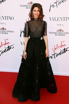 a woman in a black dress poses on the red carpet for an event at the hotel de