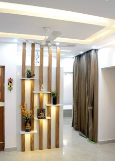 a living room filled with lots of furniture next to a wall mounted shelf covered in plants