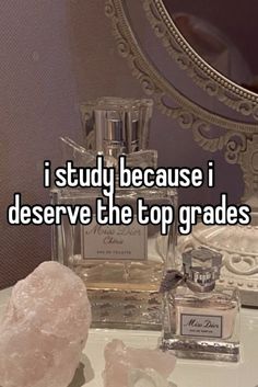 a bottle of perfume sitting on top of a table next to some rocks and crystals