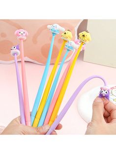 a person is holding five different colored toothbrushes in their left hand and the other one has an animal head on it