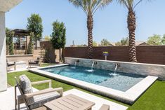 a backyard with a swimming pool surrounded by palm trees