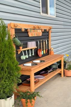 a potted plant next to a wooden bench with pots and pans on it