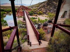 a wooden suspension bridge over a river in the desert