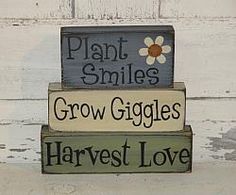 three wooden signs that say plant smiles, grow giggles, harvest love and plant smiles