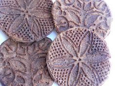 four brown cookies with intricate designs on them