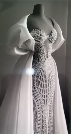 a white dress on display in front of a wall with light coming through the window