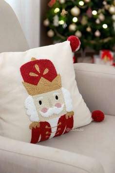 a white chair with a christmas pillow on it