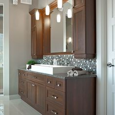 a bathroom with wooden cabinets and marble counter tops