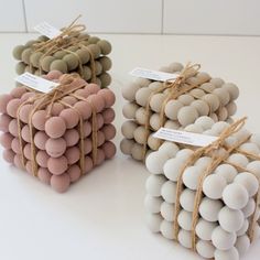 three different colored balls tied together on a white table with brown twine around them