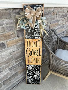 a wooden sign that says home sweet home with a bow on it next to a wicker chair