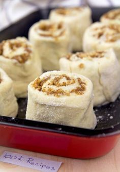 cinnamon rolls in a red pan on a wooden table