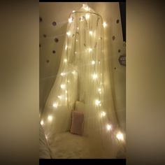 a white canopy bed with lights on it