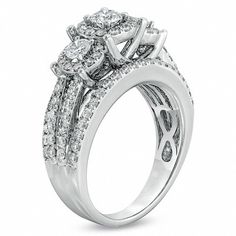 a white gold engagement ring set with three stones on the side and an oval diamond center