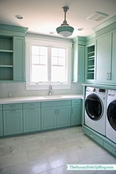 a washer and dryer in a room with green cabinets