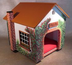 a small doll house with a bed in the middle and a red cushion under it