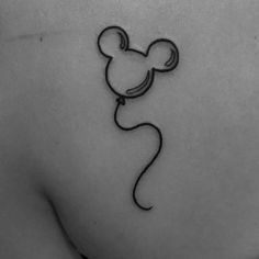 a black and white photo of a mickey mouse tattoo on the back of a woman's shoulder