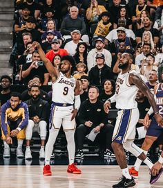 two men playing basketball in front of an audience