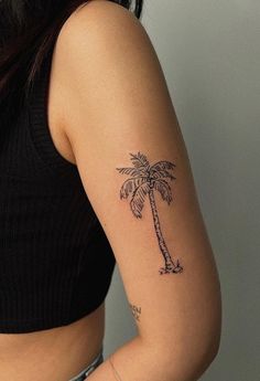 a woman with a small palm tree tattoo on her left upper arm and right lower arm