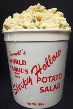 a white bucket filled with food sitting on top of a black table next to a wall