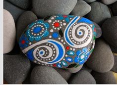 a painted rock sitting on top of some rocks