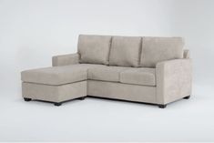 a beige sectional couch sitting on top of a white floor