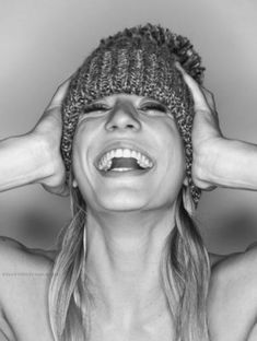 a woman wearing a knitted hat with her hands on her head