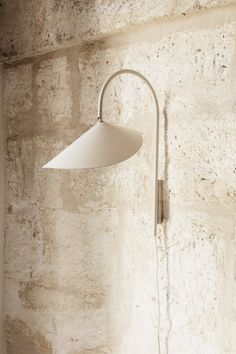 a white lamp hanging from the side of a wall