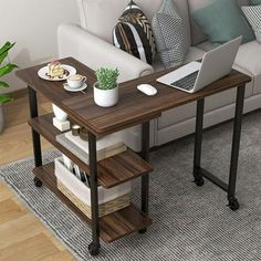 a laptop computer sitting on top of a wooden table next to a white couch in a living room