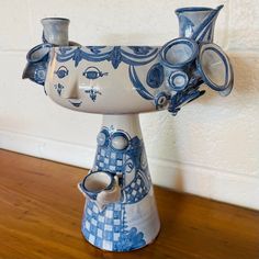 a blue and white vase sitting on top of a wooden table next to a wall