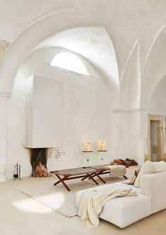 a living room with white furniture and an arched ceiling