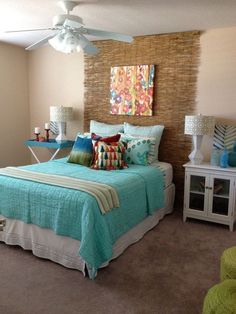 a bed room with a neatly made bed and a ceiling fan