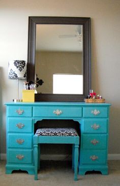 a blue dresser with a mirror on top of it