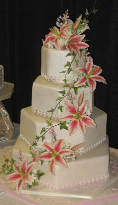 a three tiered wedding cake with pink flowers on it