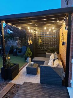 an outdoor living area is lit up with string lights