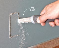 a person is using a saw to cut through the wall with a screwdriver