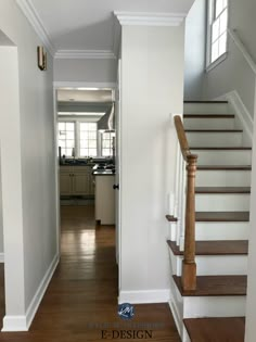 an empty hallway with stairs leading up to the kitchen