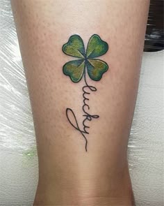 a woman's leg with a four leaf clover tattoo on it