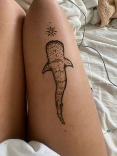 a person with a tattoo on their leg that has an image of a shark in it