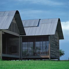 a small wooden cabin sitting on top of a lush green field