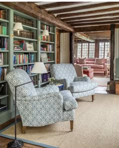 a living room filled with furniture and bookshelves covered in lots of bookcases