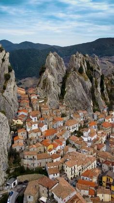 an aerial view of a small village nestled in the mountains with red roofs and brown roof tiles